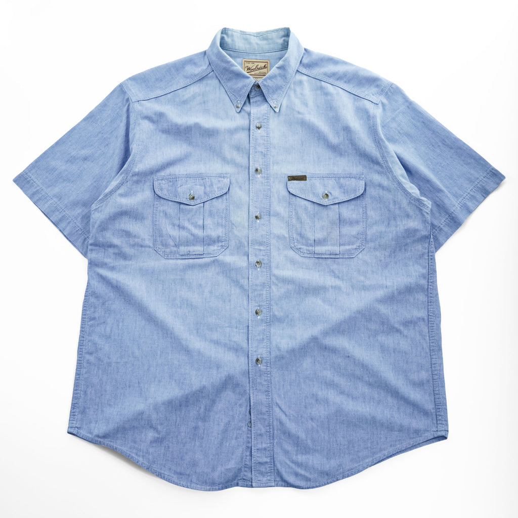 Woolrich 90s USA Made Vintage short sleeve chambray shirt light blue 100% cotton button-down chest flap pockets x2 back box pleat Made in USA XL